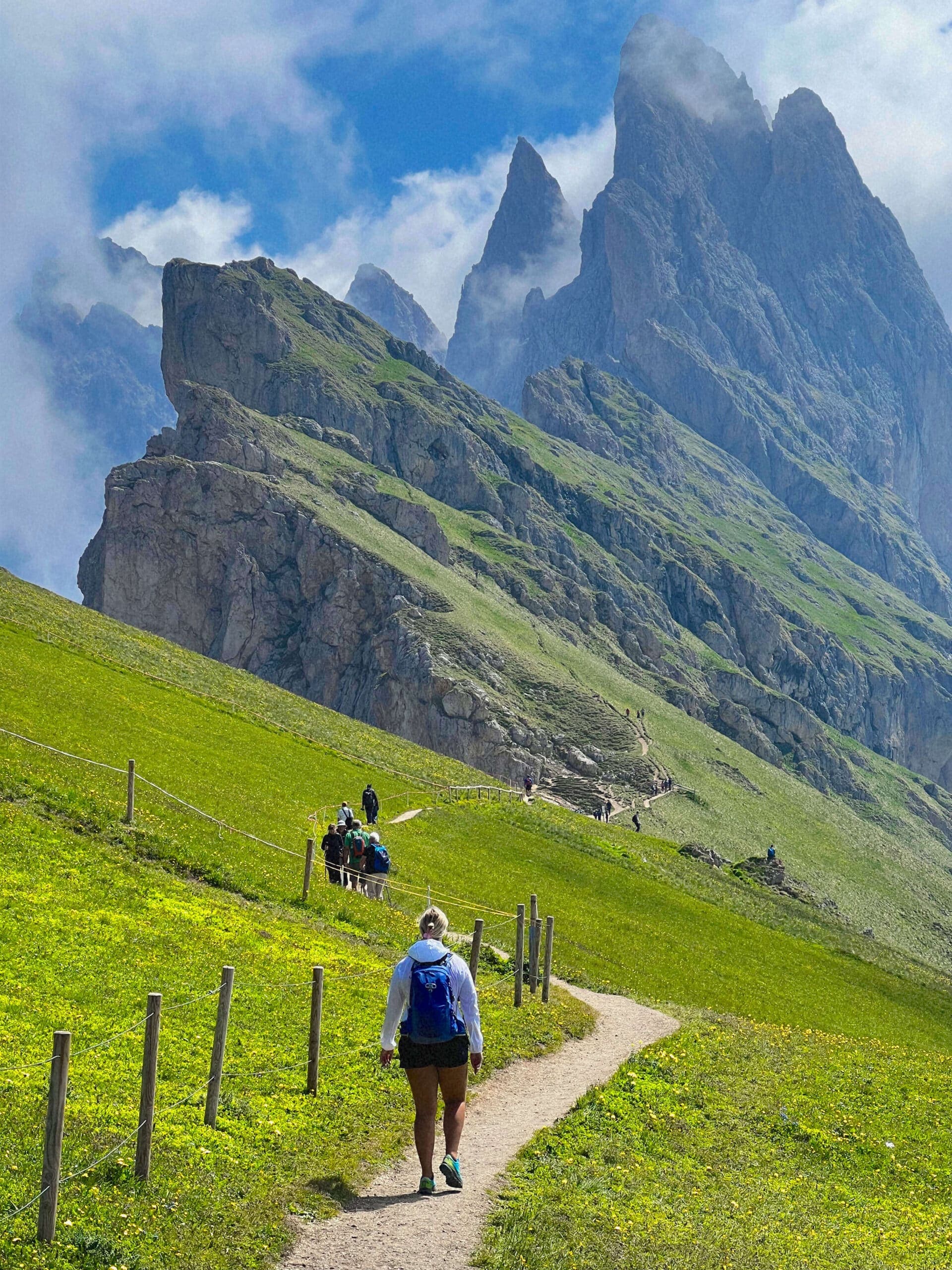 Hikers approaching the jagged Seceda ridgeline