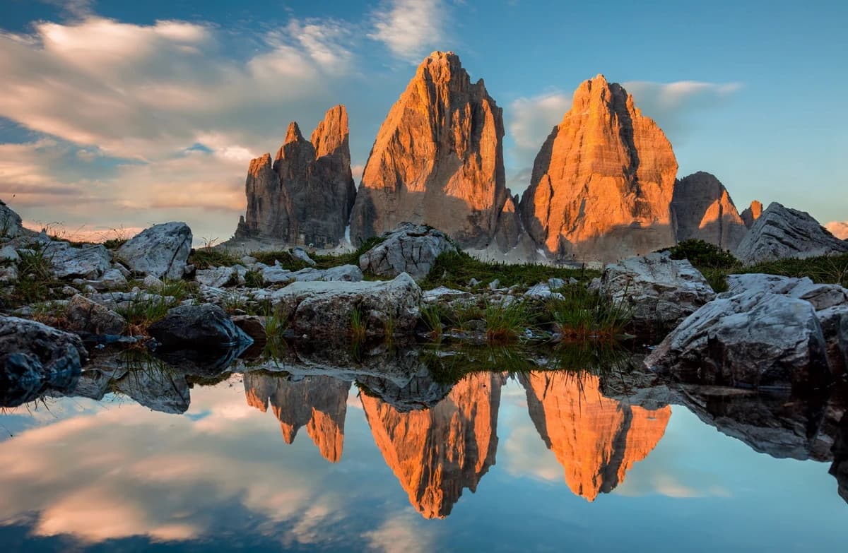 The Tre Cime di Lavaredo peaks reflected in a still alpine lake